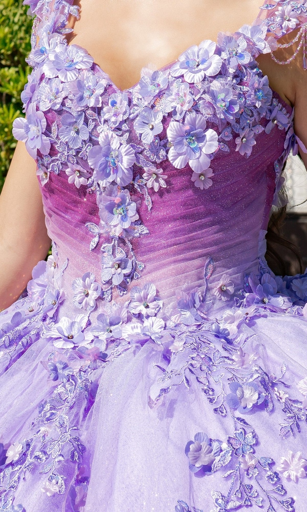 A close-up of a person wearing the Quinceanera Ball Gown 8088J, featuring lavender fabric with 3D floral lace appliqués and glittery details.